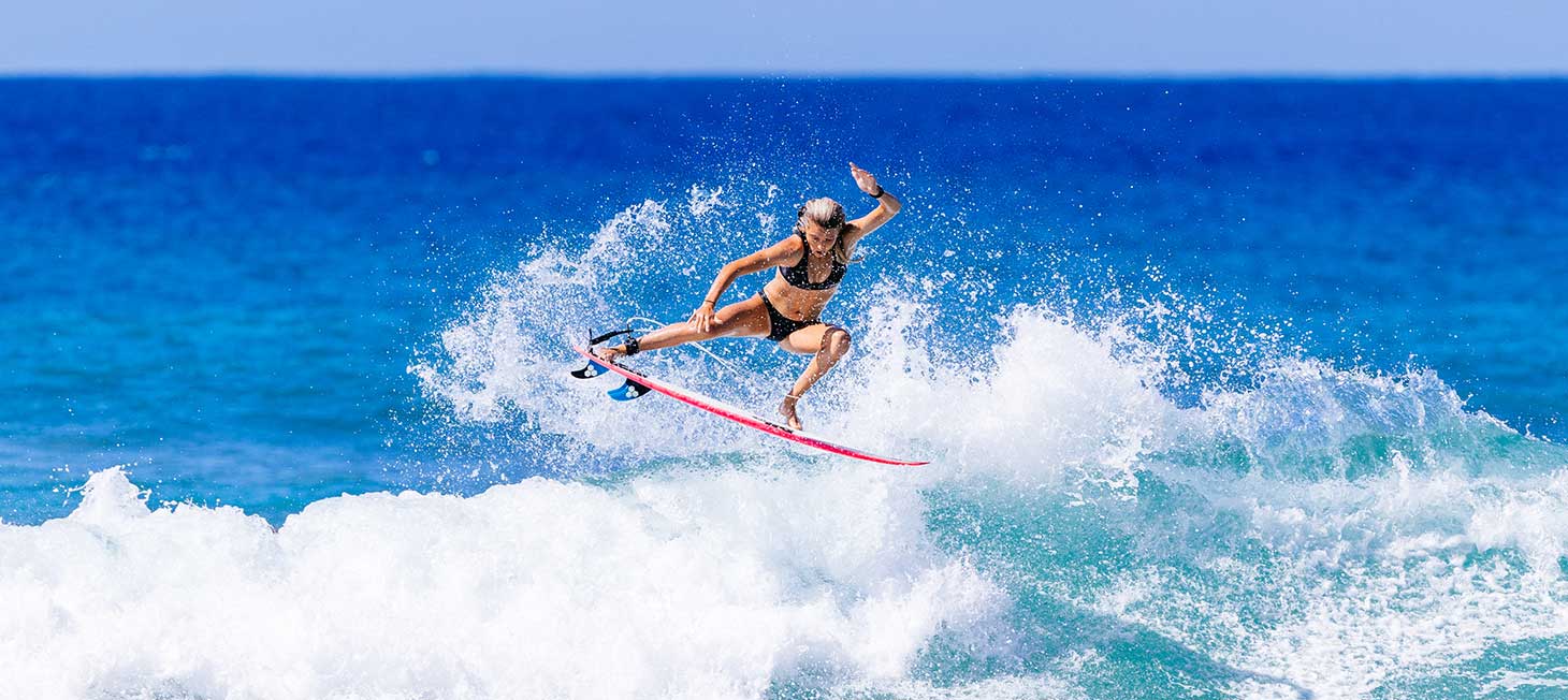 Molly Picklum stunting on a wave. Image links to video for Rip Curl's E7 Flashbomb Heatseeker wetsuit